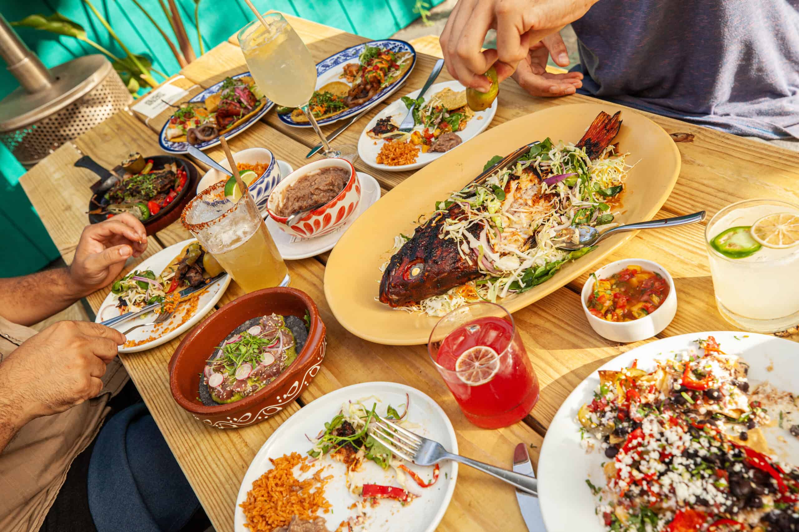 a variety of dishes and drinks with hands